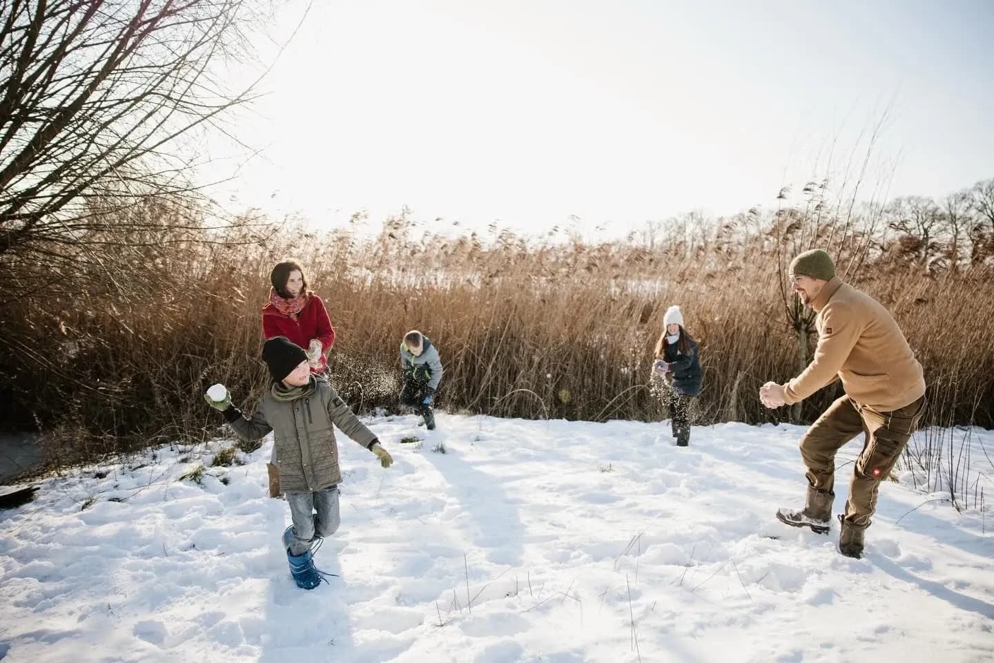 Gezin sneeuwballen in de sneeuw