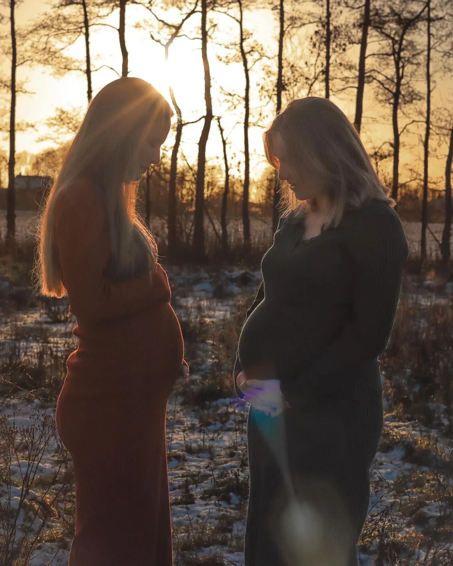 Twee zwangere vrouwen in silhouette bij zonsondergang